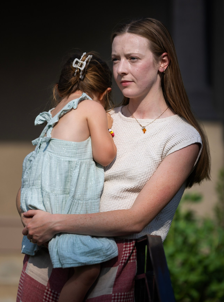 A photo of a woman holding a child. The photo is tall and narrow. The woman&rsquo;s face is near the top of the image.